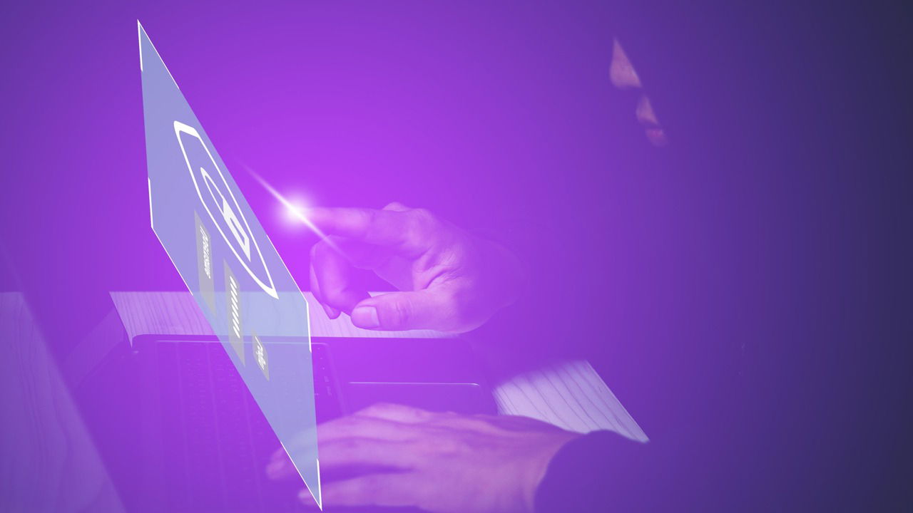 shady man accessing a login page with a laptop on table