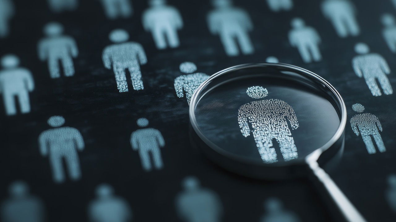 A magnifying glass focusing on person icon with many little icons