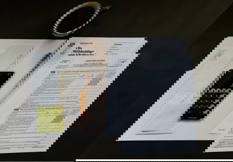 Documents fiscaux près de la tasse de café.