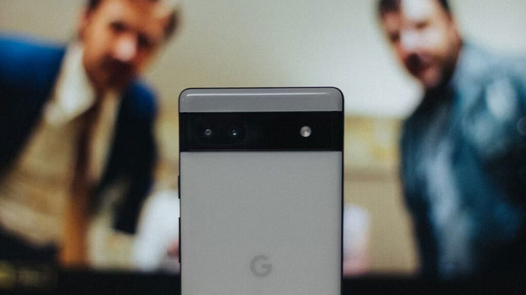 Two men looking a closeup of a Google Pixel 6a phone.