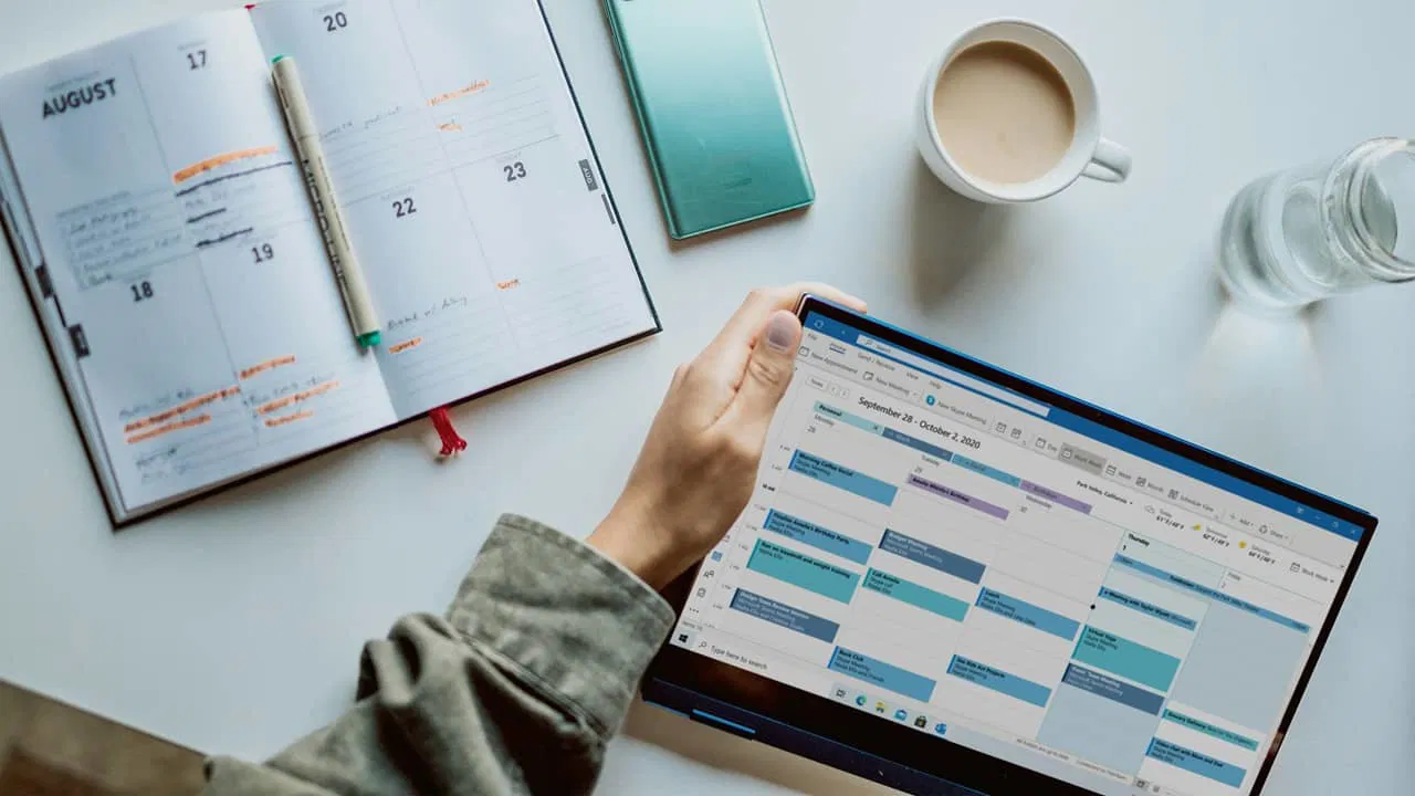 Person looking at a timeblocking schedule and personal planner.