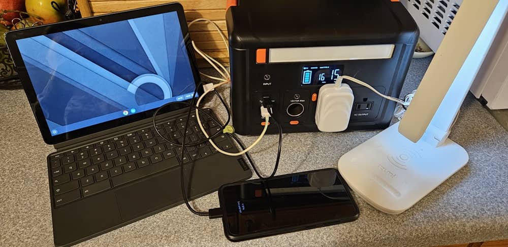 Chromebook, téléphone et lampe branchés sur une centrale électrique.