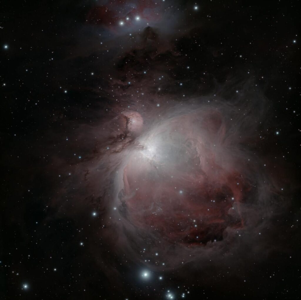 Stunning capture of the Orion Nebula (M42) with sparkling stars and vibrant emission clouds.