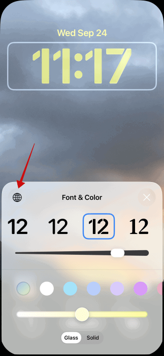 En appuyant sur l’icône du globe sur l’écran de verrouillage de l’iPhone.