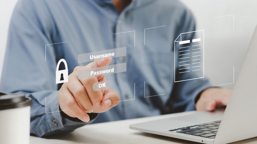 A man with a laptop on table tapping on a login screen hologram