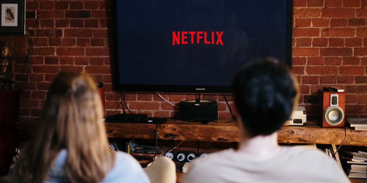 un couple dans son salon occupé à regarder Netflix sur sa TV
